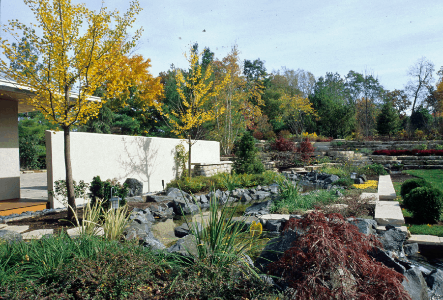 Glencoe landcaping project by Van Zelst features a pond and bluestone boulders.