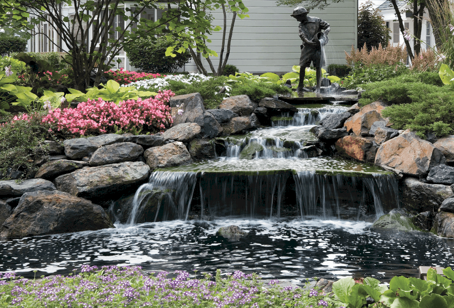 Lake Geneva landscaping project by van zelst featuring large fountain and bronze statue.