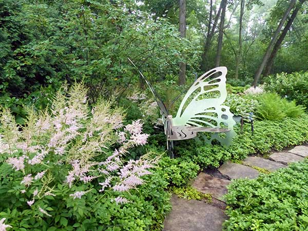 butterfly garden sculpture with pink astilbe