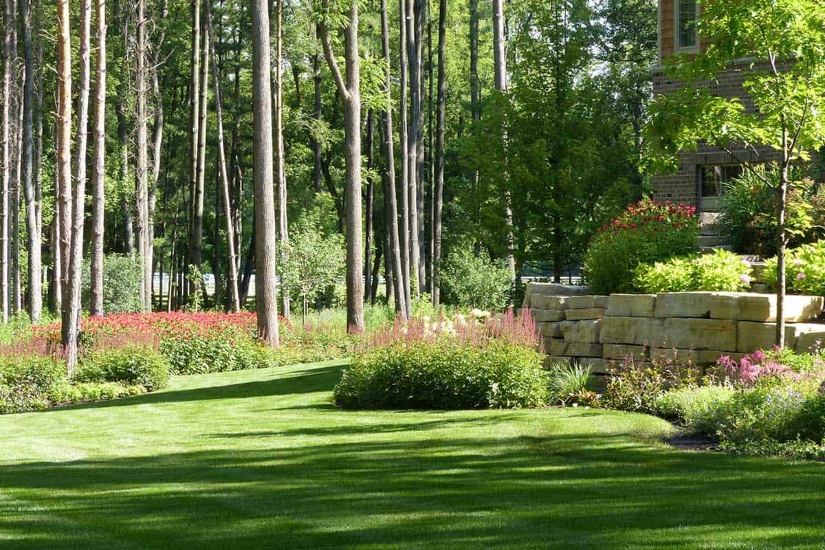 natural stone retaining wall with sweeping perennial beds