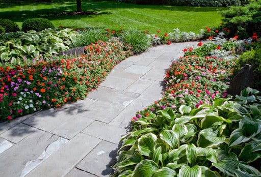 winding bluestone pathway lined with annuals